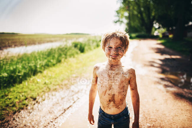 Retrato de menino de pé fora coberto de sujeira — Fotografia de Stock