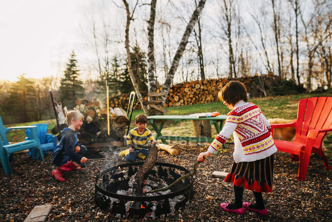 Three children sitting around a campfire — Stock Photo