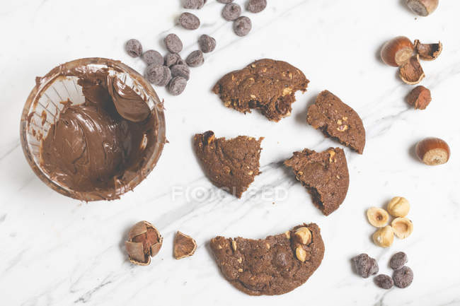 Chocolate chip cookies with hazelnuts over white background — Stock Photo