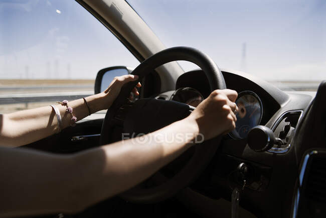 Corte tiro de mulher dirigindo através do deserto — Fotografia de Stock