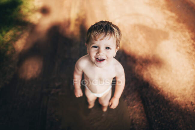 Портрет усміхненого хлопчика в підгузник, що стоїть надворі — стокове фото