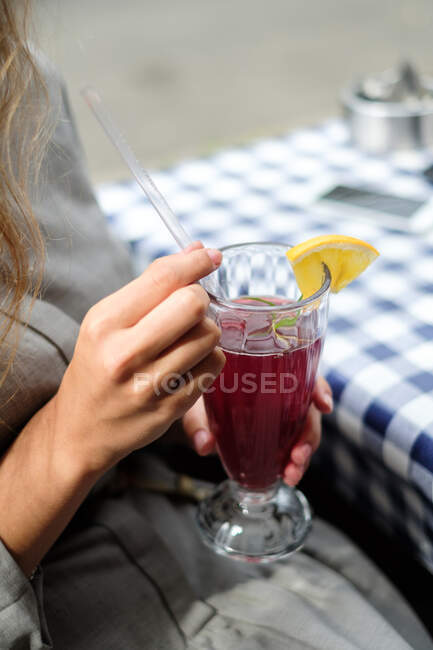 Mujer en un café bebiendo un cóctel de arándanos - foto de stock