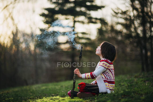 Mädchen bläst einen Rauchstab — Stockfoto