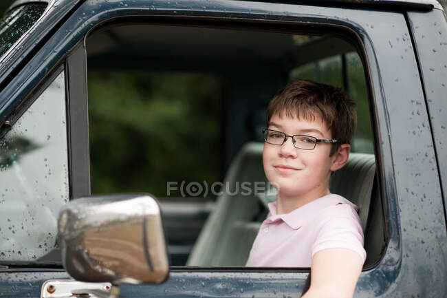 Adolescente sentado em uma caminhonete — Fotografia de Stock