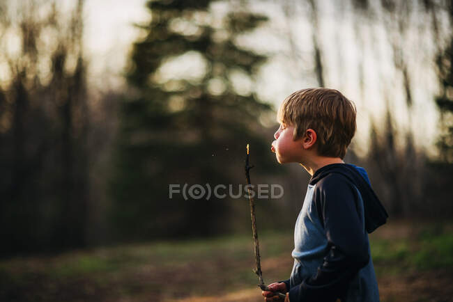 Мальчик дул палкой в лесу — стоковое фото