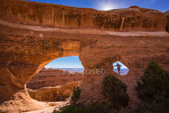Uomo in piedi nel Partition Arch, Arches National Park, Utah, America, USA — Foto stock