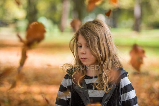 Portrait of a girl throwing autumn leaves in the air, Bulgaria — Stock Photo