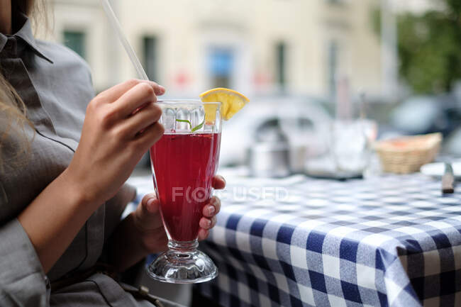 Frau trinkt in Café einen Preiselbeercocktail — Stockfoto