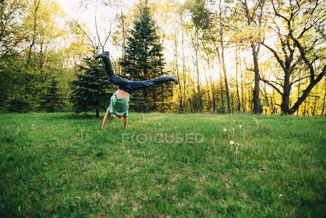 Boy doing a cartwheel in the garden — Stock Photo