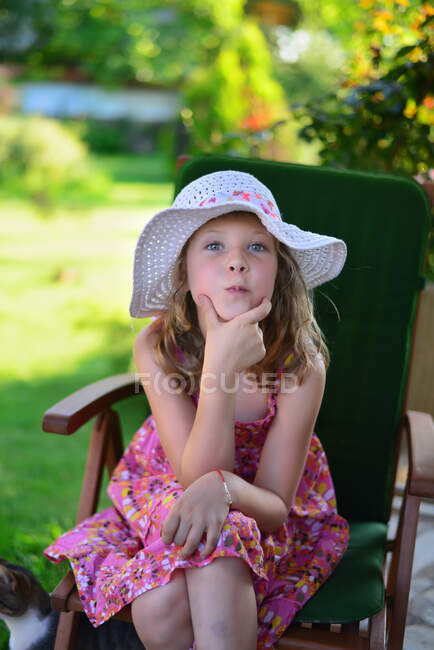 Retrato de una chica con la mano en la barbilla tirando de una cara divertida - foto de stock