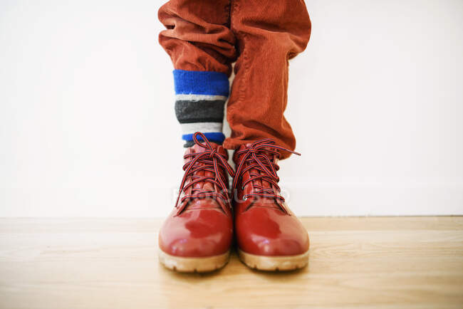 Primer plano de un chico con sus pantalones metidos en uno de sus calcetines - foto de stock
