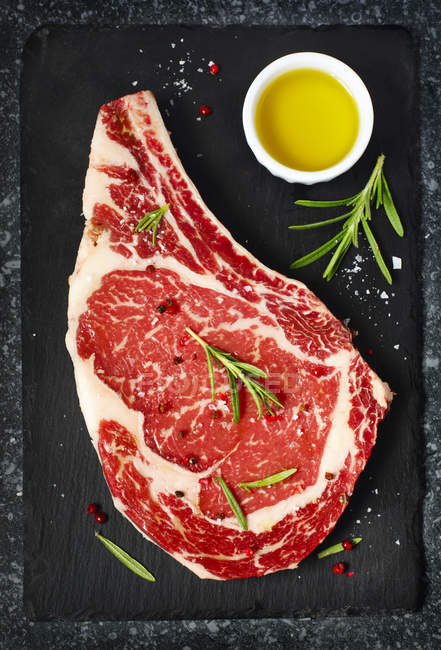 Roh gealtertes Steak auf schwarzem Hintergrund, Draufsicht — Stockfoto
