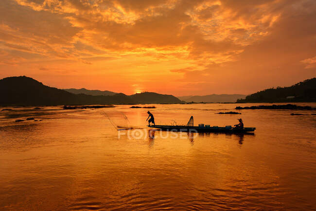 Під час заходу сонця, під час заходу сонця, рибалка, рибалка, що підриває сіті, під час заходу сонця (Таїланд). — стокове фото