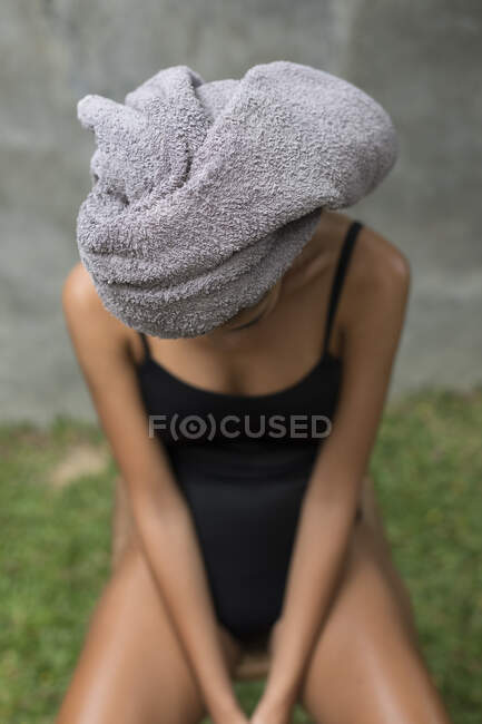 A young woman wearing a grey head towel is preparing for her facemask after a shower in a tropical balinese villa. — Fotografia de Stock