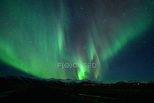 Espectacular exhibición auroral por la noche sobre la montaña, espectacular auroral y estrella por la noche, Islandia - foto de stock