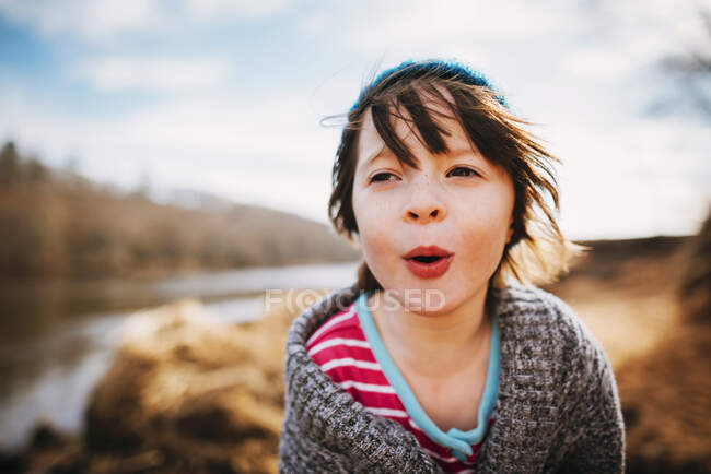 Young girl playing in the sand by a river — Stock Photo