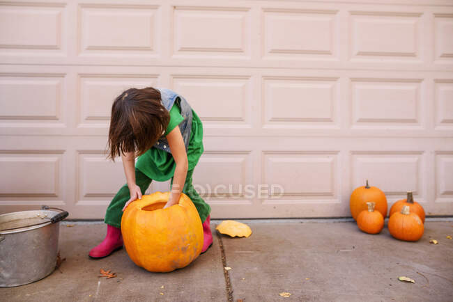 Una giovane ragazza intagliando una zucca — Foto stock