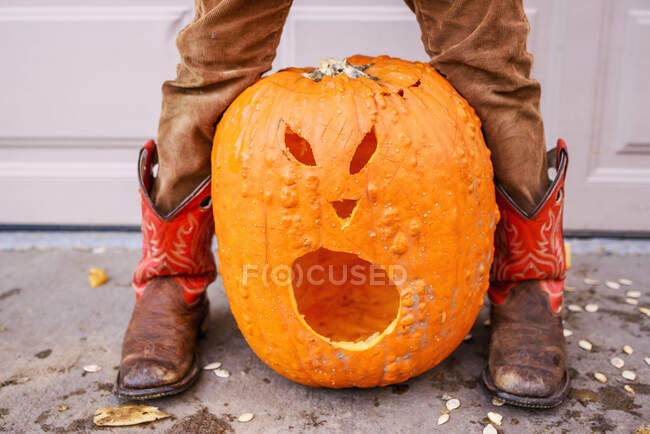 Close up of carved pumpkin and child's legs — Stock Photo
