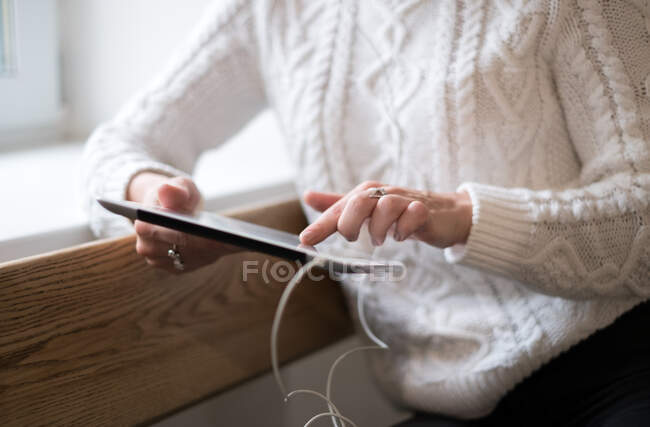 Woman leaning against a wall using a digital tablet — Stock Photo