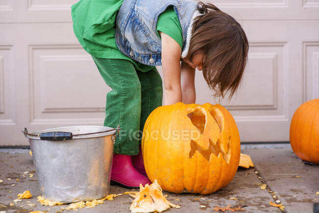 A young girl carving a pumpkin — Stock Photo