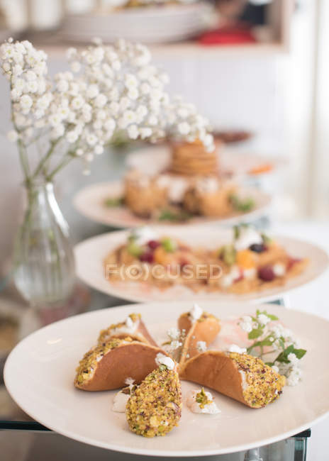 Puddinggefüllte Pfannkuchen über weißen Tellern auf dem Serviertisch — Stockfoto