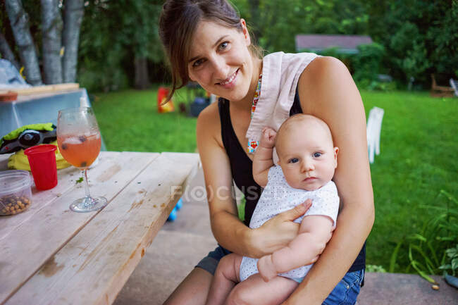 Mãe segurando pequeno bebê lá fora no verão — Fotografia de Stock