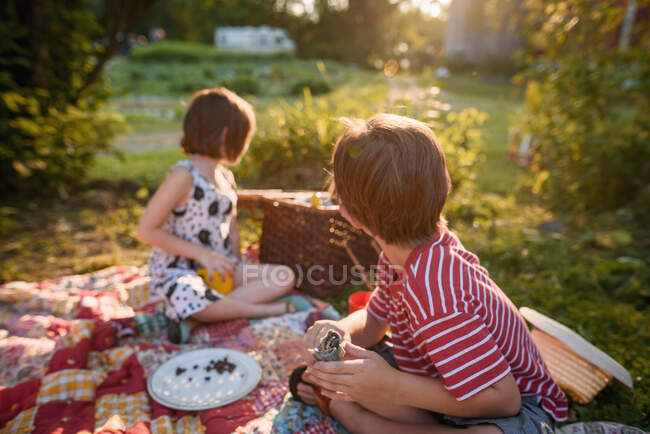 Duas crianças pequenas fazendo um piquenique à noite — Fotografia de Stock
