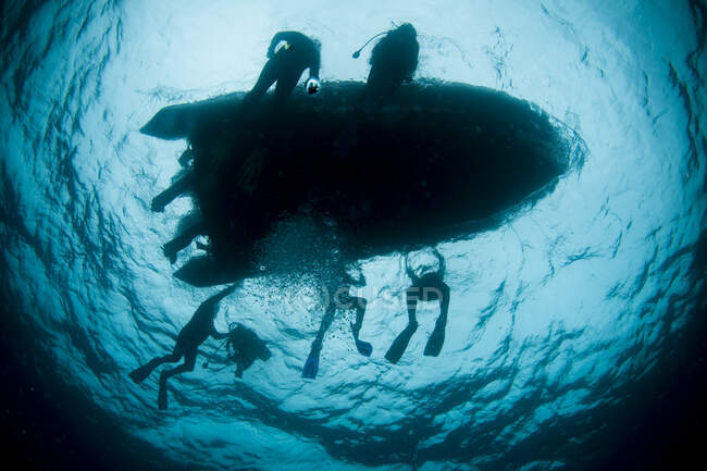 Подводный силуэт из пяти водолазов на подводной лодке — стоковое фото