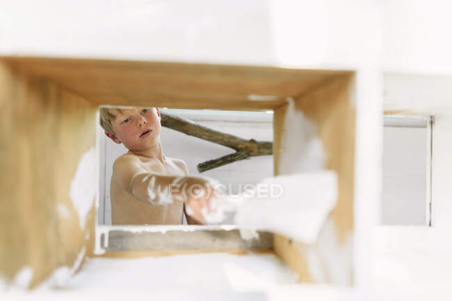 Young child painting a chicken coop — Stock Photo