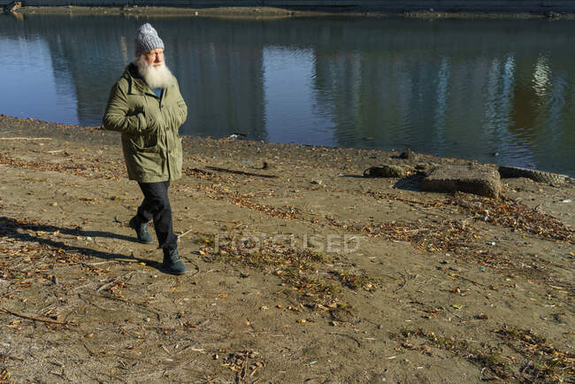 Viejo mira el atardecer junto al río - foto de stock