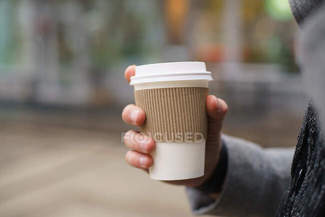 Man is drinking coffee. Close up of hand with cup of coffee, wooden background with copy-space blank for your text or advertisement logo. Early morning routine — Stock Photo