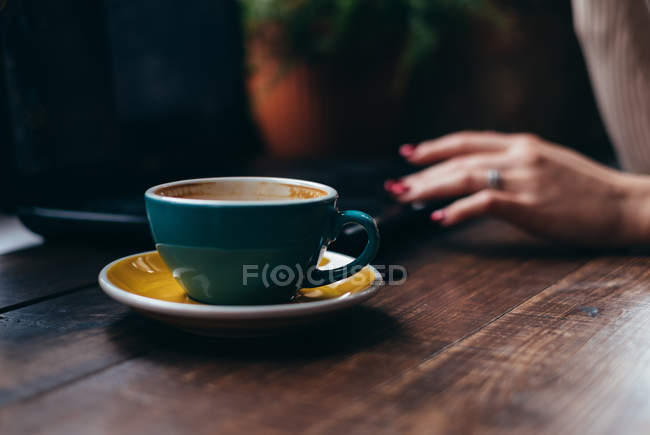 Жінка подає поруч з чашкою кави — стокове фото