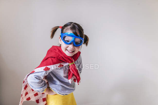 Jeune fille dans une cape super héros et masque — Photo de stock