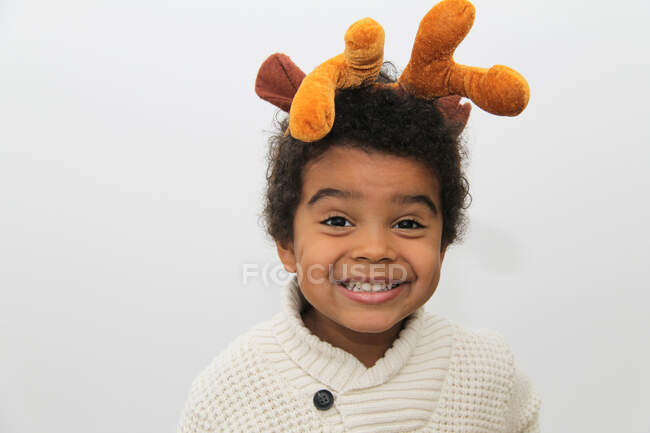Porträt eines lächelnden Jungen mit Weihnachtsgeweih — Stockfoto