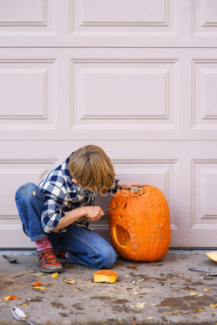 Close up of young boy carving a pumpkin. — Stock Photo