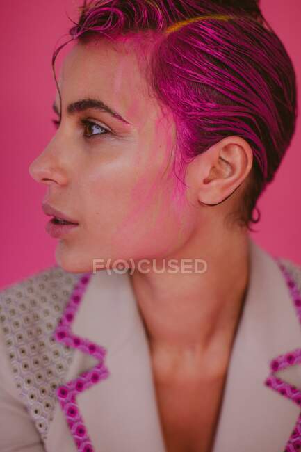 Retrato de una mujer con pelo rosa y tinte para el cabello corriendo por su cara - foto de stock