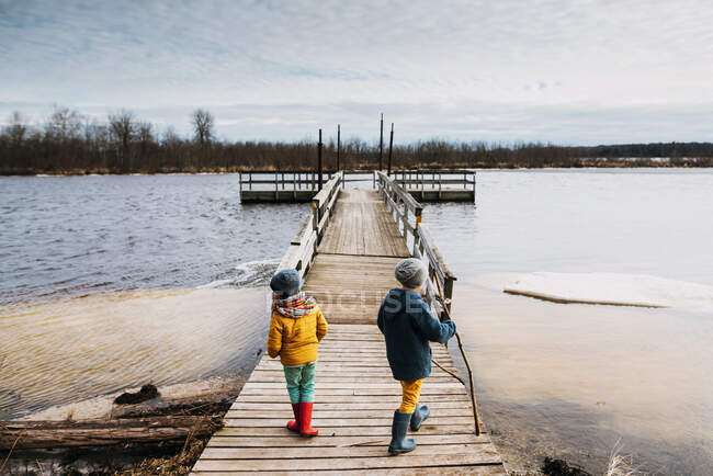 Two young boys on a dock over a frozen lake — Stock Photo