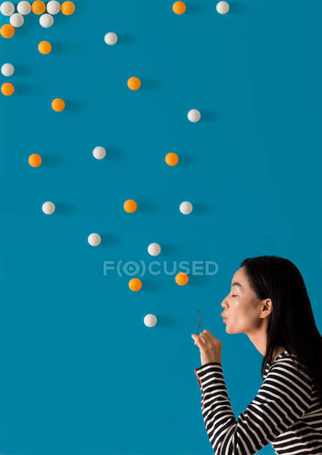 Femme soufflant des bulles conceptuelles — Photo de stock