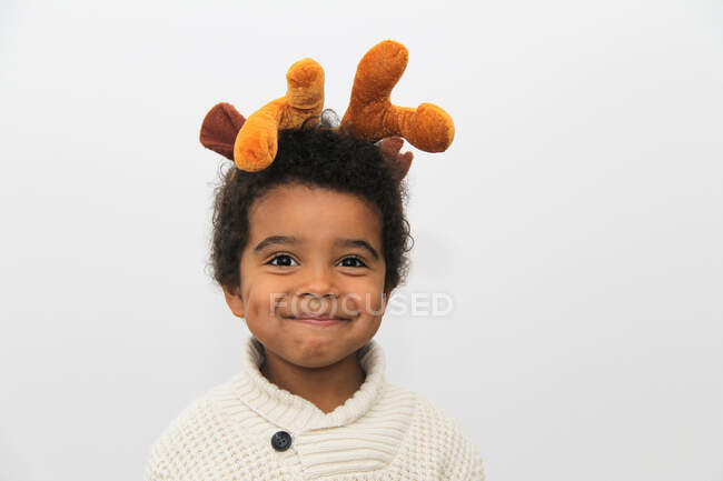 Портрет улыбающегося мальчика с рождественскими рогами — стоковое фото