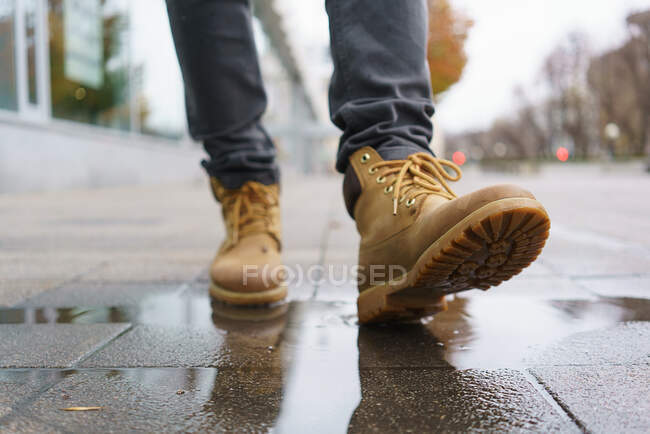 Крупним планом вид на ноги в джинсах і черевиках на тротуарі — стокове фото