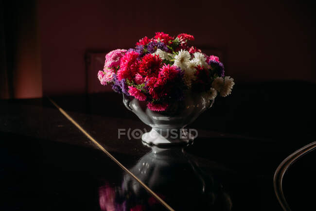 Buquê de flores em um vaso em uma mesa — Fotografia de Stock
