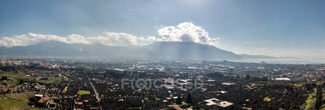 Вид с воздуха на город с далекими горами — стоковое фото