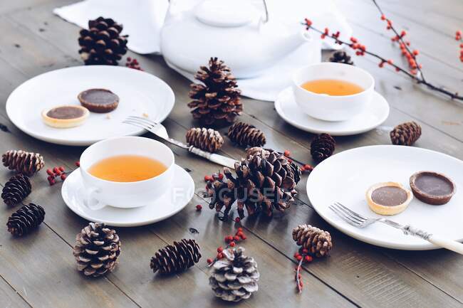 Рождественская композиция с чашками напитков на деревянной поверхности — стоковое фото