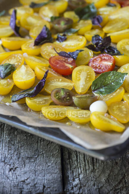 Colorful mix of different types of halved tomatoes — Stock Photo