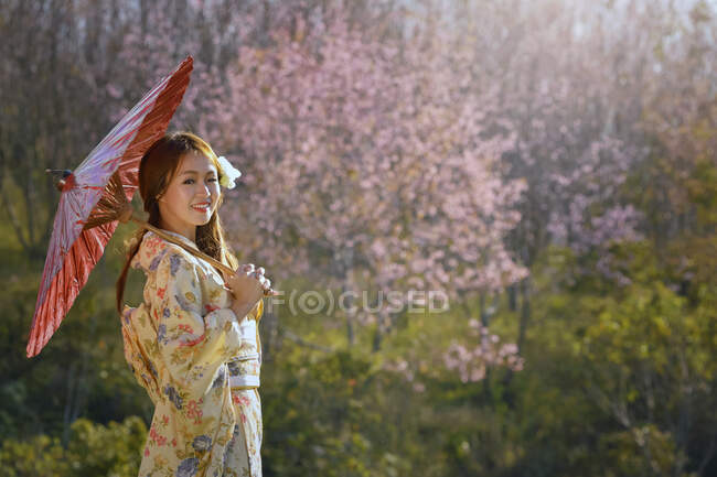 Прекрасна жінка, що бореться з джапаном, весняний сакура вишневий цвіт, рожеві квіти сукура квіти, вінтажний стиль — стокове фото