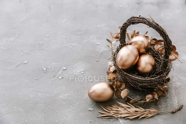 Oeufs de Pâques dans un nid sur la surface de la pierre — Photo de stock