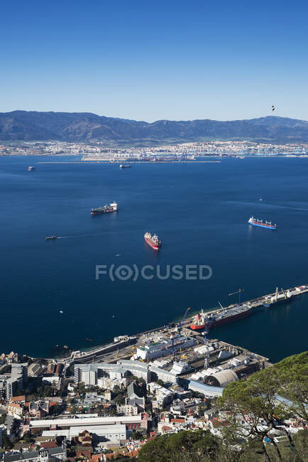 Vista del porto soleggiato con navi ormeggiate e montagne — Foto stock