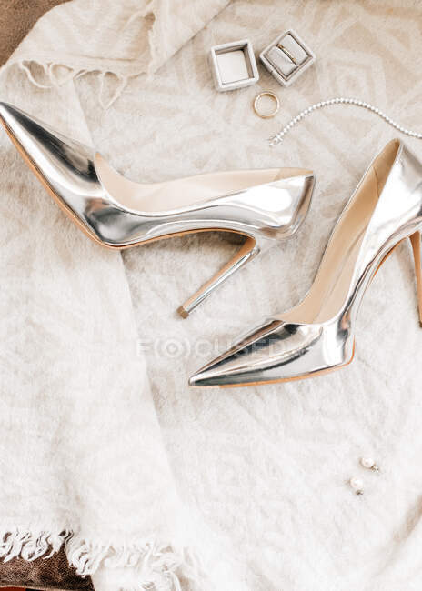 Top view of white wedding shoes with a bow tie and other stuff on a light background — Stock Photo