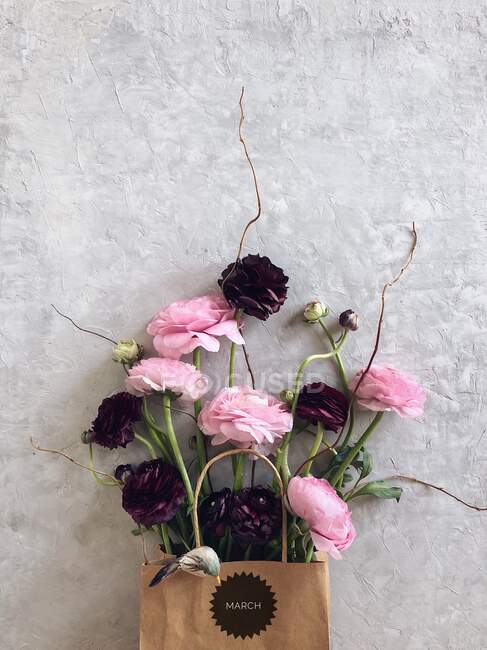 Цветы Ranunculus в бумажном пакете с мартовским дуршлагом — стоковое фото