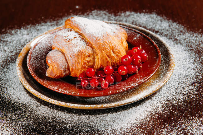 Closeup view of Sweet croissant with redcurrants — Stock Photo